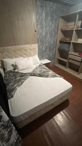1 dormitorio con 1 cama y armario con estanterías en lar doce lar, en Gramado