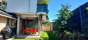 a house with a porch with a table and chairs at Studio Apartment in Collingwood Park