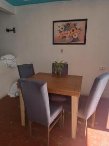 ein Esstisch mit zwei Stühlen und einem Bild an der Wand in der Unterkunft Alma Andrea in San Cristóbal de las Casas