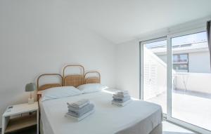 ein weißes Schlafzimmer mit einem Bett und einem großen Fenster in der Unterkunft Amazing Apartment In Marina Di Modica in Marina di Modica