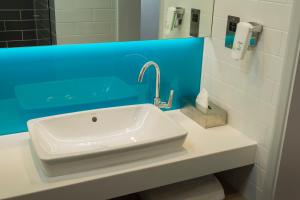 a white sink in a bathroom with a blue wall at Holiday Inn Express St. Albans - M25, Jct.22 in Saint Albans