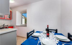 un tavolo blu con una bottiglia di vino sopra di 3 Bedroom Awesome Home In Krk a Risika