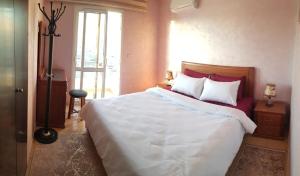 a bedroom with a large white bed and a window at luxury apartment in Agadir