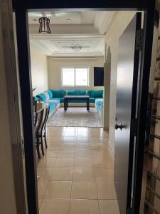 a living room with a blue couch and a table at luxury apartment in Agadir