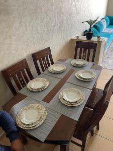 a wooden table with chairs and plates on it at luxury apartment in Agadir