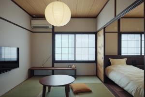 熊本Kotobukisou 民泊ことぶき荘 Free Parking 10 mins by car Kumamoto Station的客房设有床、桌子和窗户。