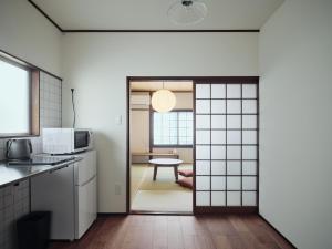 熊本Kotobukisou 民泊ことぶき荘 Free Parking 10 mins by car Kumamoto Station的厨房设有通往桌子的门