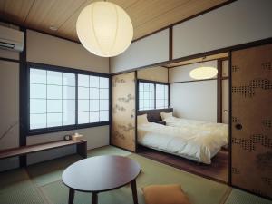 熊本Kotobukisou 民泊ことぶき荘 Free Parking 10 mins by car Kumamoto Station的带床和桌子的卧室