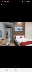 a hotel room with a bed and a desk at Phoenix Living in Surabaya