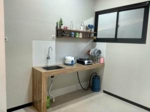 a kitchen with a counter with a sink and a window at Phoenix Living in Surabaya