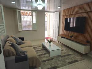 a living room with a couch and a flat screen tv at Casa Hospedagem Belém - COP 30 in Belém