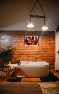 a bath tub in a room with a brick wall at Yaktari Cabaña del Sol in Otavalo +29 photos