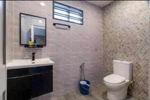 a bathroom with a toilet and a sink and a mirror at Luxury Villa in Ayer Keroh +7 photos