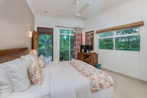 una camera da letto con un letto bianco e una finestra di Hotel Travellers Nest Kandy a Kandy