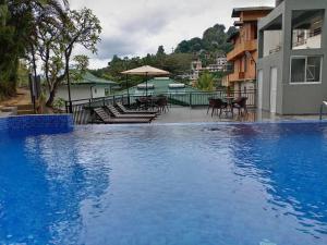 una grande piscina blu accanto a un edificio di Hotel Travellers Nest Kandy a Kandy