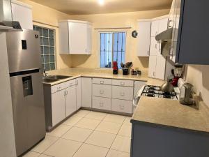 a kitchen with white cabinets and a refrigerator at Spacious Rooftop House w/ King Bed in Tijuana
