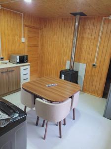 a kitchen with a wooden table and two chairs at Los Teros in Chile Chico +3 photos