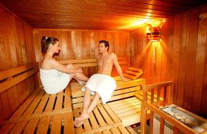 a man and a woman are standing in a bathtub at Hotel Zugspitze in Garmisch-Partenkirchen