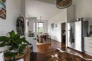 a kitchen with a refrigerator and a dining room at Black Cockatoo Bangalow in Binna Burra