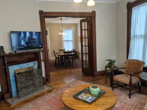 a living room with a fireplace and a tv at The John Sydney House in Hannibal