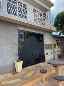 a table and two stools in front of a building at Apto 1 Central em Fátima do Sul térreo in Fatima do Sul
