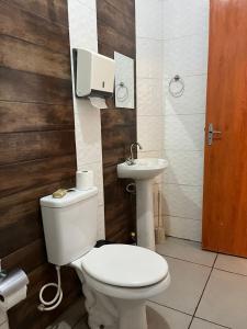 a bathroom with a toilet and a sink at Apto 1 Central em Fátima do Sul térreo in Fatima do Sul +15 photos