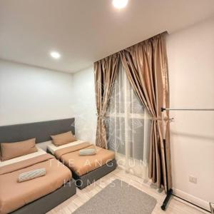 a room with two beds and a window at The Anggun Sutera Avenue Homestay in Kota Kinabalu