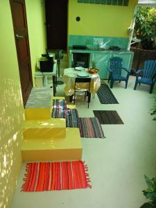 a living room with a table and chairs and rugs at Le papayer in Afareaitu