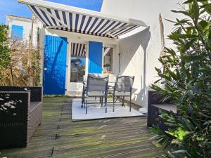 a patio with chairs and a table on a deck at Maisonnette proche plage et forêt, parking, wifi - FR-1-476-230 in La Faute-sur-Mer