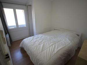 ein weißes Bett in einem Zimmer mit Fenster in der Unterkunft Maison cosy 3 ch., proche marché et télécabine à Luchon - FR-1-313-237 in Luchon