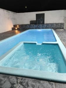 une grande piscine avec de l'eau bleue dans l'établissement mongaguá house 1 km, à Mongaguá