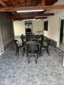 un groupe de tables et de chaises dans une pièce dans l'établissement mongaguá house 1 km, à Mongaguá 5 autres photos