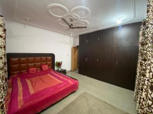 una camera da letto con un letto grande e un ventilatore a soffitto di VisitingVillah a Srinagar