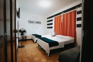 a bedroom with two beds and a fan in it at Tequila Sunrise Hostel in Guatemala +61 photos