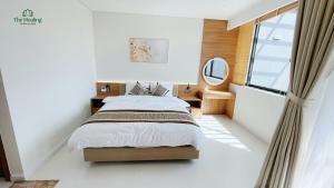 a bedroom with a bed and a large window at The Healing Luxury Hotel in Buon Ma Thuot