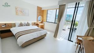 a bedroom with a bed and a large window at The Healing Luxury Hotel in Buon Ma Thuot