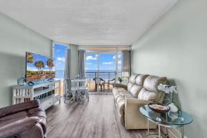 uma sala de estar com um sofá e uma mesa em Hosteeva 1BR Oceanfront Condo in Atlantica Resort near Boardwalk em Myrtle Beach