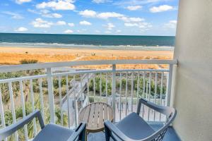 uma varanda com cadeiras e vista para a praia em Hosteeva 1BR Oceanfront Condo in Atlantica Resort near Boardwalk em Myrtle Beach mais 20 fotografias
