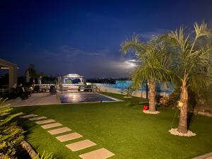 a resort yard with palm trees and a swimming pool at Alto do Moinho in Alcobaça