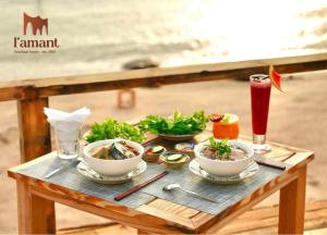 - une table avec des bols de nourriture et de boissons dans l'établissement L'amant Boutiqué House Phú Quý, à Cu Lao Thu