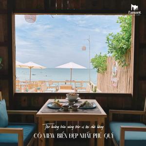 - une table avec des assiettes de nourriture et une vue sur la plage dans l'établissement L'amant Boutiqué House Phú Quý, à Cu Lao Thu
