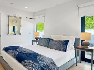 a bedroom with a large bed with blue pillows at Villa Caliente in Palm Springs +58 photos