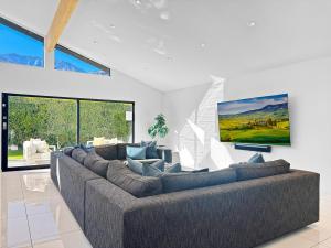 a living room with a large couch and a tv at Villa Caliente in Palm Springs