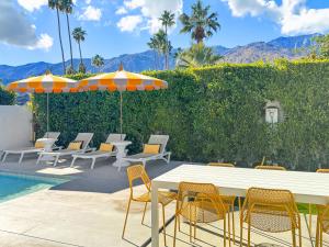 a patio with a table and chairs and a pool at Villa Caliente in Palm Springs
