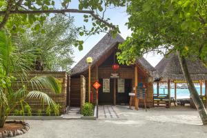 a restaurant on the beach with a straw roof at Adaaran Club Rannalhi - All Inclusive - 45 Minutes away from Male by Speedboat in South Male Atoll