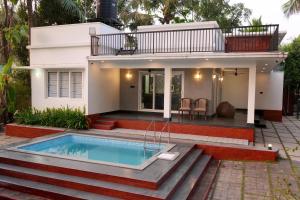 a house with a swimming pool in front of it at Serene Retreat in Cochin
