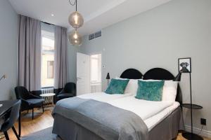 una camera da letto con un grande letto bianco con cuscini blu di Clarion Collection Hotel Borgen a Örebro