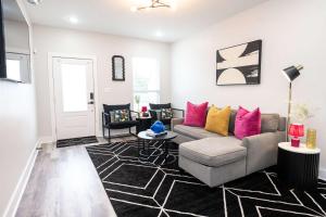 a living room with a gray couch and pink pillows at Mid City Magic 5 in New Orleans
