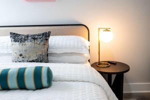 a bed with a pillow and a table with a lamp at Mid City Magic 5 in New Orleans