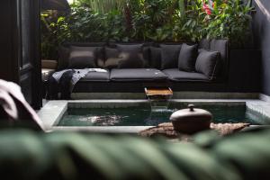 a living room with a couch and a pond at The Bohemian Bali, a Member of Design Hotels in Canggu
